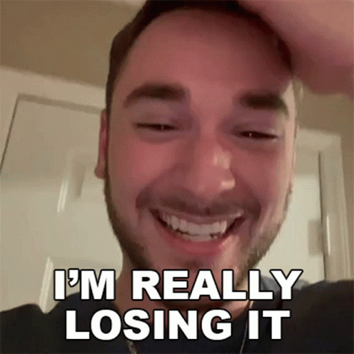 a man with a beard is smiling and holding his head .