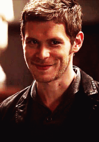 A Man With A Beard Is Smiling And Wearing A Black Shirt GIF