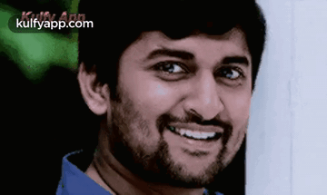 A Man With A Beard Is Smiling And Wearing A Blue Shirt GIF