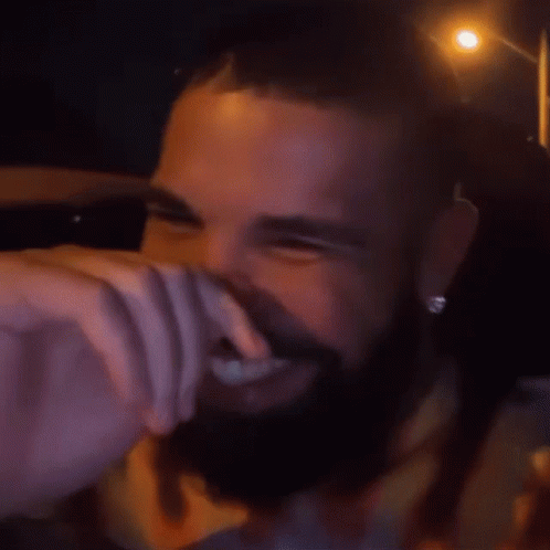 A Man With A Beard Is Smiling And Wearing A Shirt That Says ' Paris ' On It GIF
