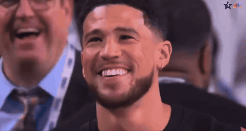 A Man With A Beard Is Smiling In A Crowd Of People GIF