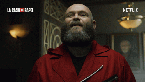 A Man With A Beard Is Smiling In A La Casa De Papel Advertisement GIF
