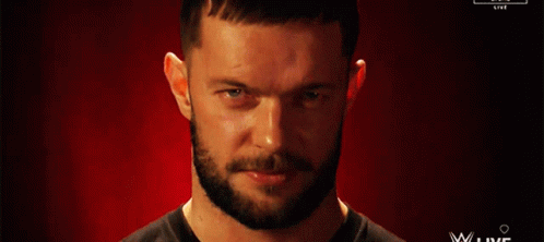 A Man With A Beard Is Smiling In Front Of A Red Background That Says Wwe Live GIF