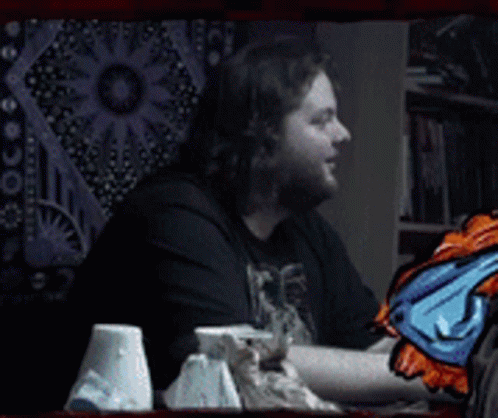 A Man With A Beard Is Smiling In Front Of A Wall Tapestry And The Words Dafug ? GIF