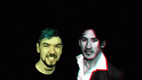 A Man With A Beard Is Smiling Next To Another Man With Red Eyes GIF