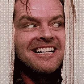 A Man With A Beard Is Smiling While Looking Out Of A Doorway . GIF