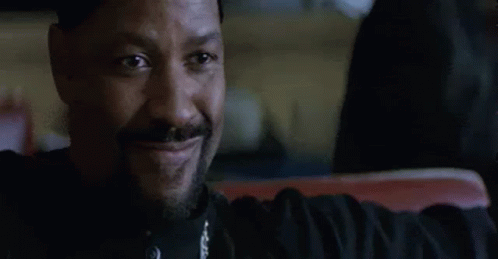 A Man With A Beard Is Smiling While Sitting In A Car . GIF