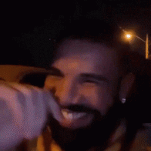 A Man With A Beard Is Smiling With His Eyes Closed And His Mouth Open . GIF