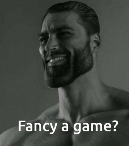 A Man With A Beard Is Smiling With The Words Fancy A Game Behind Him GIF