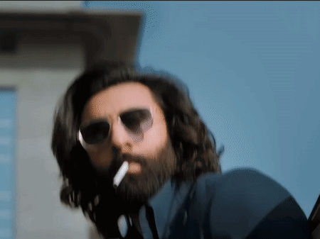 A Man With A Beard Is Smoking A Cigarette GIF