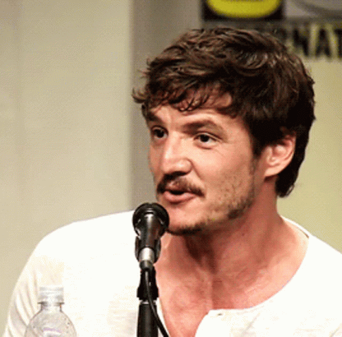 A Man With A Beard Is Speaking Into A Microphone While Holding A Bottle Of Water GIF