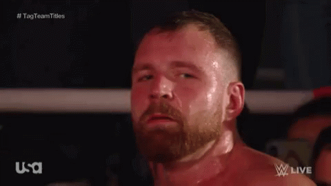 A Man With A Beard Is Standing In A Boxing Ring Looking At The Camera . GIF
