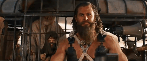 A Man With A Beard Is Standing In A Cage With Other People GIF