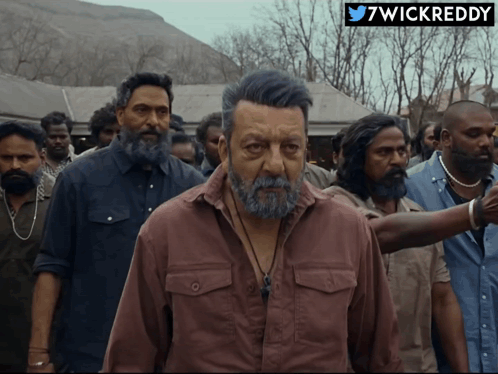 A Man With A Beard Is Standing In A Crowd With A 7Wickreddy Logo On The Bottom GIF