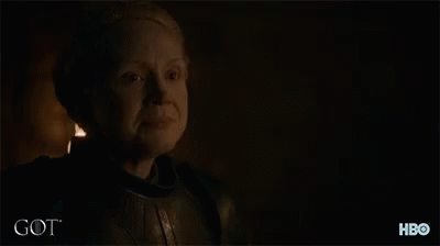 A Man With A Beard Is Standing In A Dark Room With The Word Got Written On The Bottom GIF