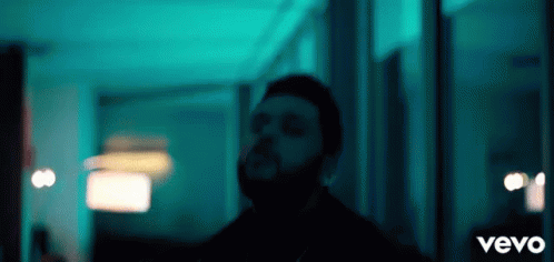 A Man With A Beard Is Standing In A Dark Room With The Word Vevo On The Bottom GIF