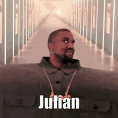 A Man With A Beard Is Standing In A Hallway With The Name Julian On It . GIF