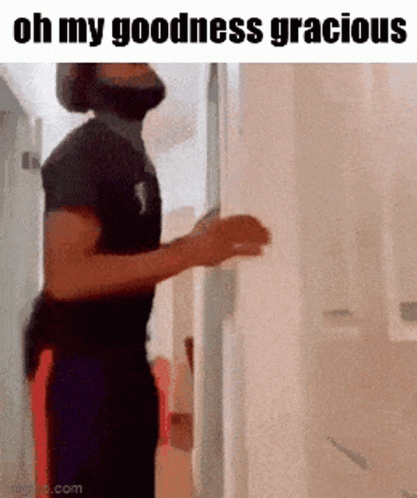 A Man With A Beard Is Standing In A Hallway With The Words Oh My Goodness Gracious Above Him . GIF