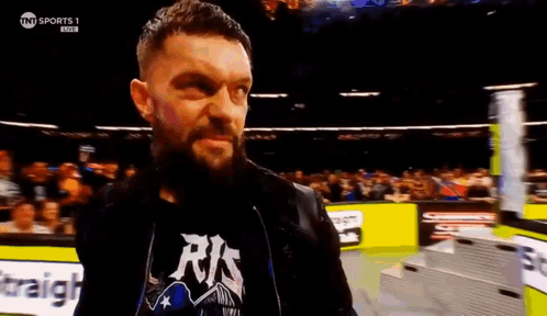 A Man With A Beard Is Standing In A Wrestling Ring . GIF