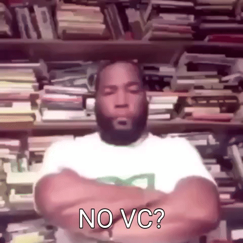 A Man With A Beard Is Standing In Front Of A Bookshelf With His Arms Crossed And Says No Vc . GIF