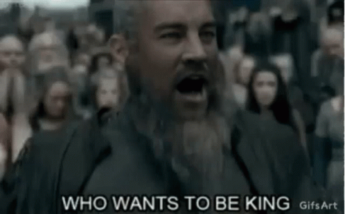 A Man With A Beard Is Standing In Front Of A Crowd Of People And Yelling . GIF