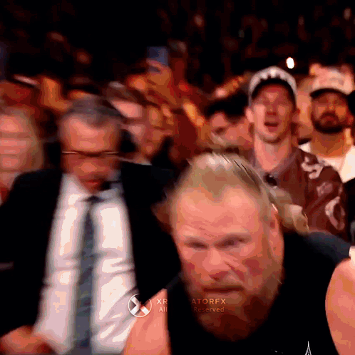 A Man With A Beard Is Standing In Front Of A Crowd With The Word Atorfx On The Bottom Right Corner GIF