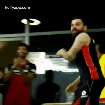 A Man With A Beard Is Standing In Front Of A Group Of People . GIF