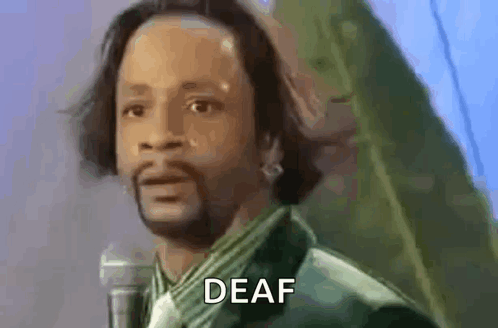 A Man With A Beard Is Standing In Front Of A Microphone And Says Deaf . GIF