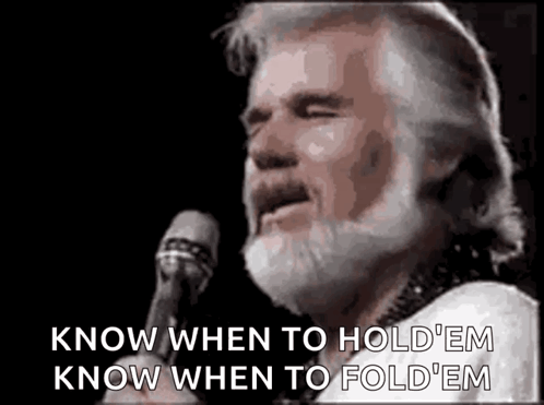 A Man With A Beard Is Standing In Front Of A Microphone And Singing . GIF