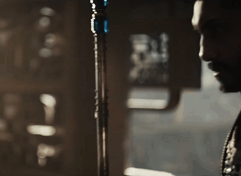 A Man With A Beard Is Standing In Front Of A Microphone . GIF
