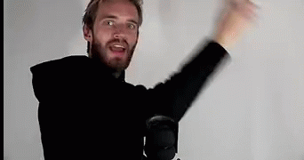 A Man With A Beard Is Standing In Front Of A Microphone With His Arms In The Air . GIF
