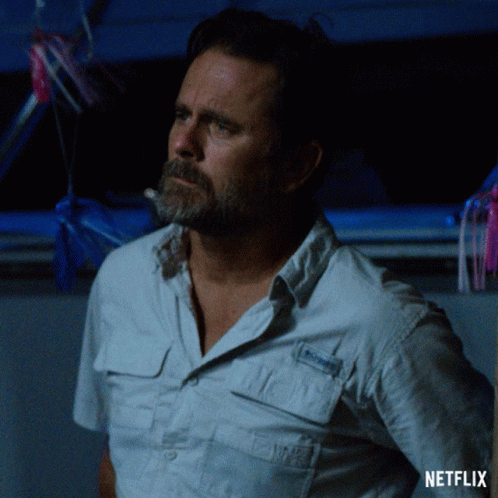 a man with a beard is standing in front of a netflix sign