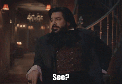 A Man With A Beard Is Standing In Front Of A Staircase And Says " See " GIF