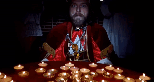 A Man With A Beard Is Standing In Front Of A Table With Candles And Says I Am The Pope Of Dope GIF