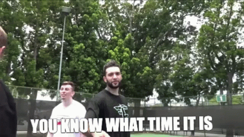 A Man With A Beard Is Standing In Front Of A Tennis Court With The Words " You Know What Time It Is " Below Him GIF
