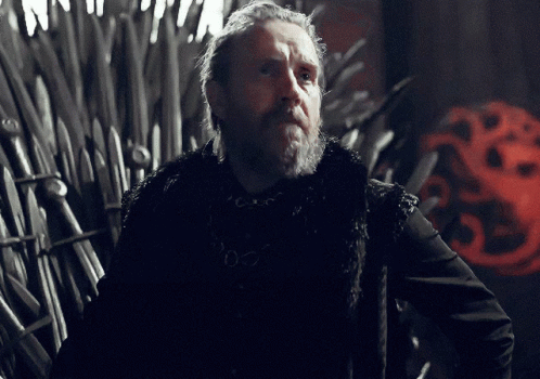 a man with a beard is standing in front of a throne with a red dragon on it