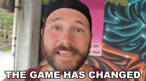 A Man With A Beard Is Standing In Front Of A Wall That Says The Game Has Changed On It GIF