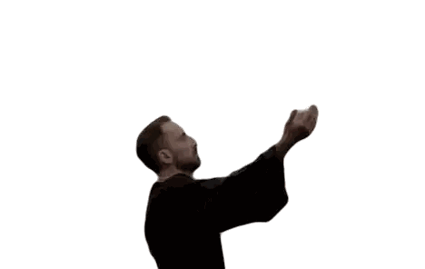 a man with a beard is standing in front of a white background with his hands outstretched .