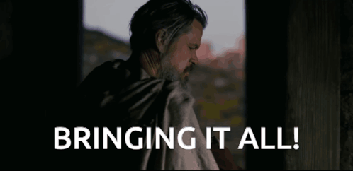 A Man With A Beard Is Standing In Front Of A Window And Says Bringing It All . GIF