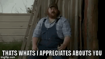 A Man With A Beard Is Standing In Front Of A Wooden Fence . GIF
