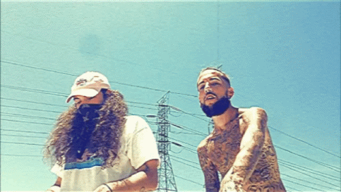 A Man With A Beard Is Standing Next To A Man With Long Hair GIF