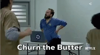 A Man With A Beard Is Standing Next To A Table With A Laptop On It . GIF