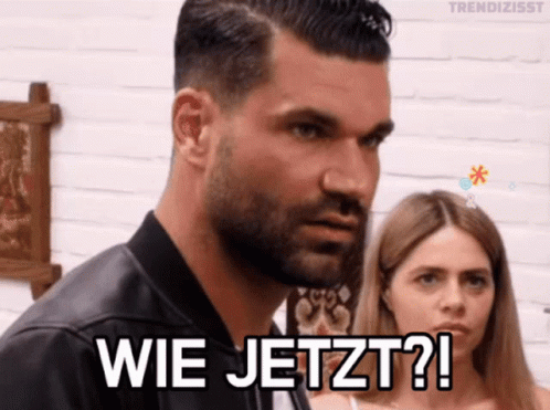 A Man With A Beard Is Standing Next To A Woman And Says " Wie Jetzt " GIF