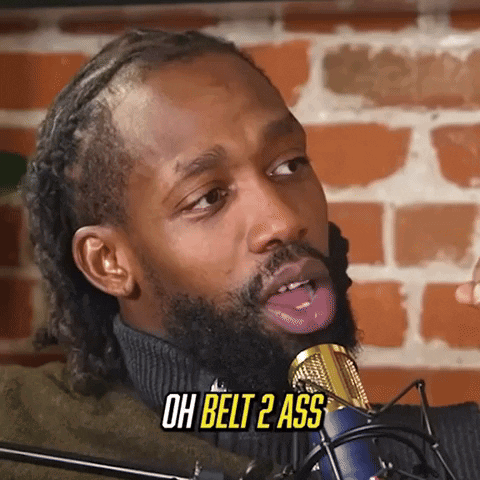 A Man With A Beard Is Sticking His Tongue Out In Front Of A Microphone And Says Oh Belt 2 Ass . GIF