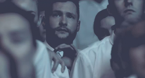 A Man With A Beard Is Surrounded By Other People In White Shirts GIF