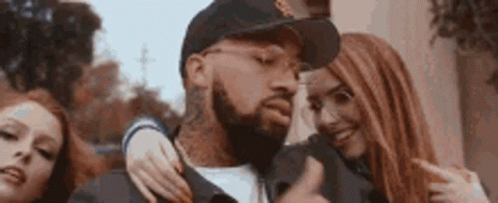 A Man With A Beard Is Surrounded By Two Women . GIF