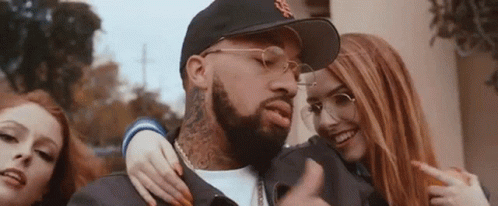 A Man With A Beard Is Surrounded By Two Women . GIF