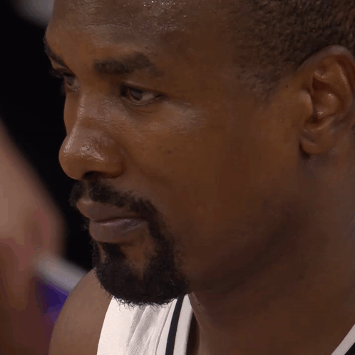 A Man With A Beard Is Sweating And Looking Down GIF