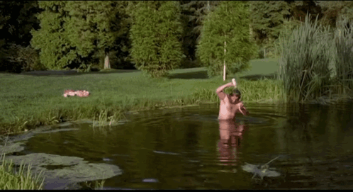 A Man With A Beard Is Swimming In A Pond . GIF