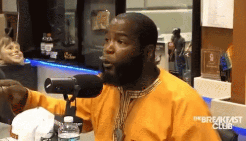 A Man With A Beard Is Talking Into A Microphone With The Breakfast Club Written On The Bottom GIF